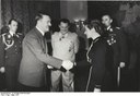 Verleihung des Eisernen Kreuzes an Hanna Reitsch durch Hitler, Schwarz-Weiß-Fotografie, 1941, unbekannter Fotograf; Bildquelle: Deutsches Bundesarchiv via Wikimedia Commons: https://commons.wikimedia.org/wiki/File:Bundesarchiv_B_145_Bild-F051625-0295,_Verleihung_des_EK_an_Hanna_Reitsch_durch_Hitler.jpg?uselang=de. Creative-Commons-Lizenz „Namensnennung – Weitergabe unter gleichen Bedingungen 3.0 Deutschland.